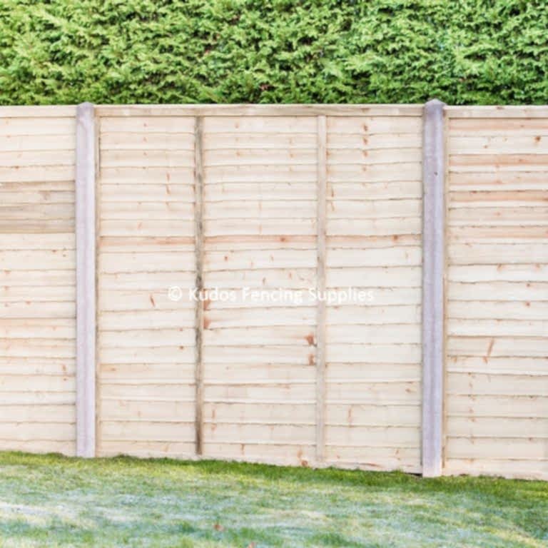Waney edge lap panels with concrete posts.