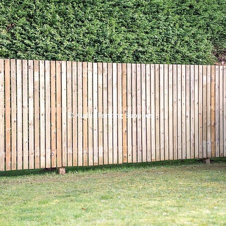 Wooden palisade fencing. Timber hit and miss fence.